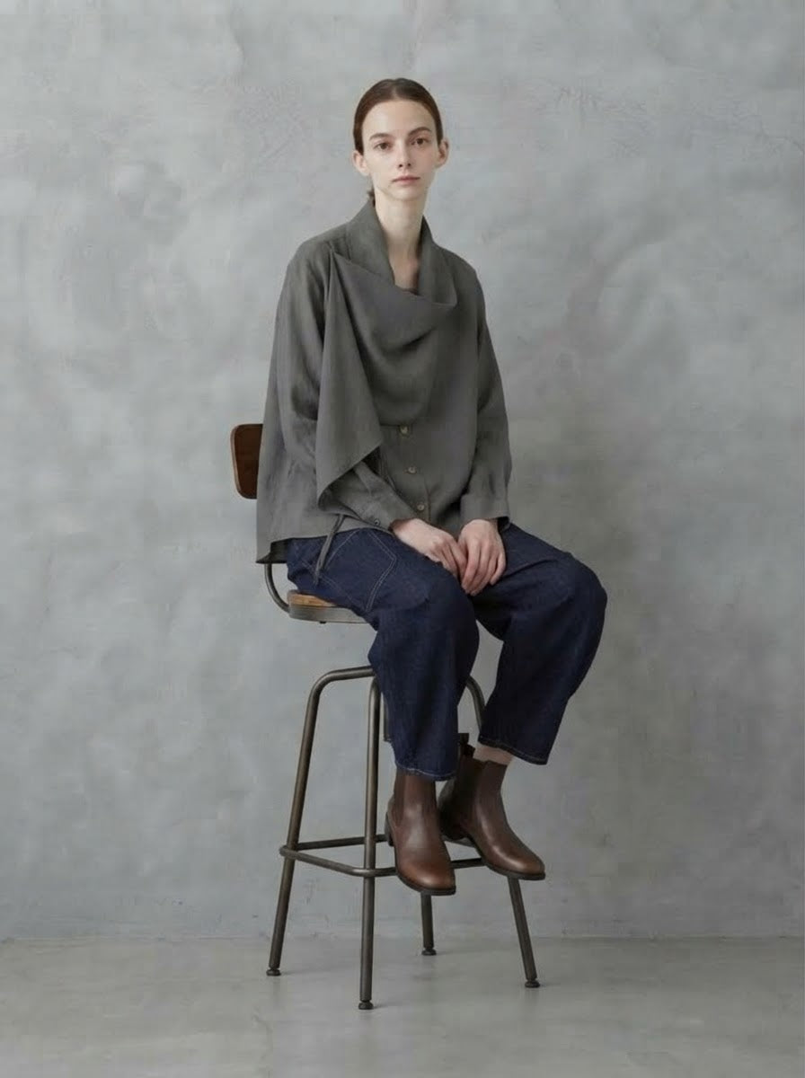 Model wearing chocolate Darla scarf collar blouse, seated view