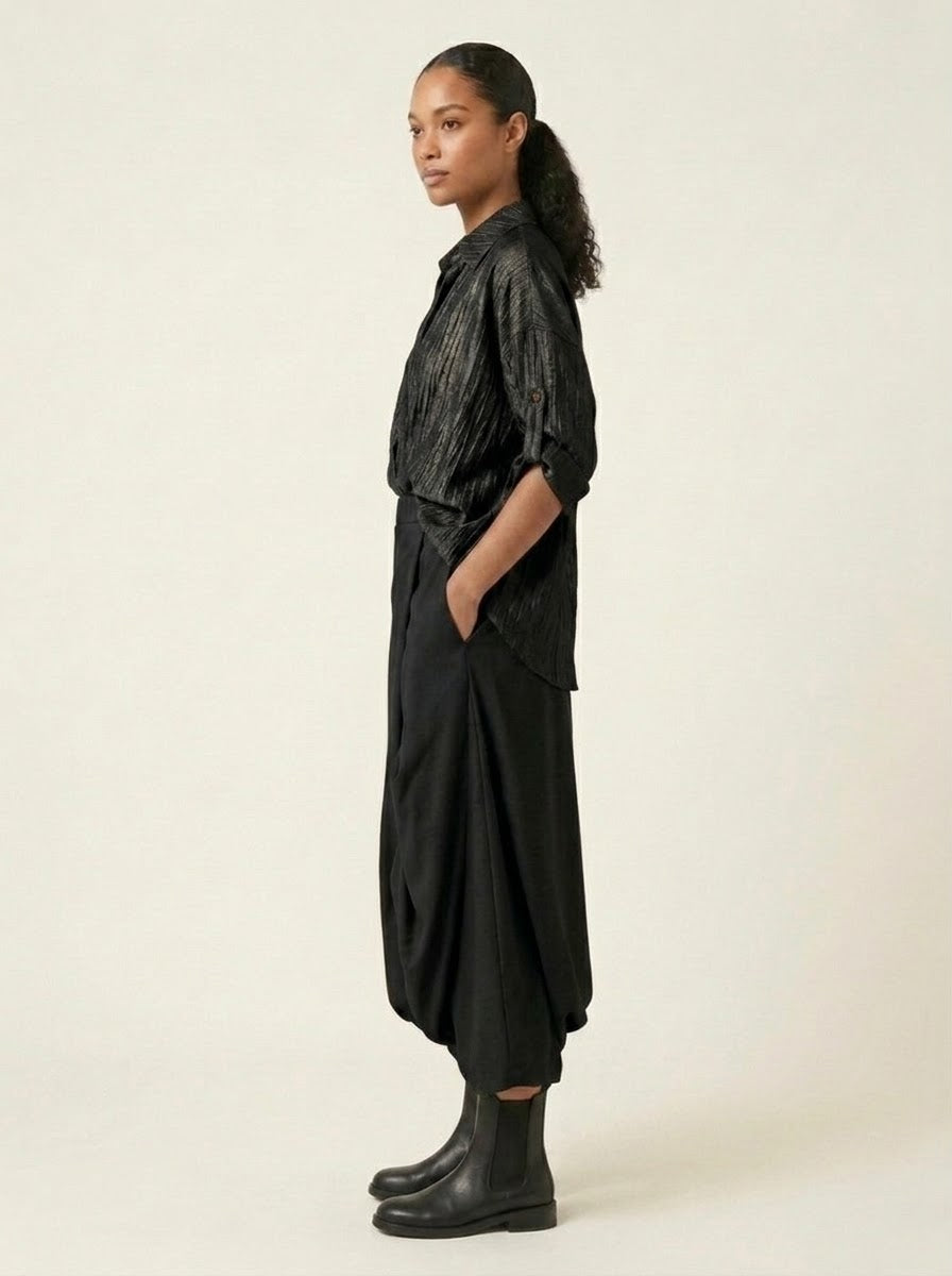 Model wearing black Roberta harem trousers, side view