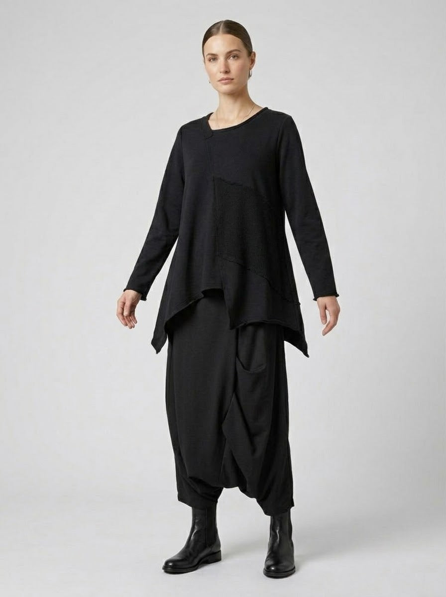 Model wearing the Matilda black asymmetric knit and sweatshirt top