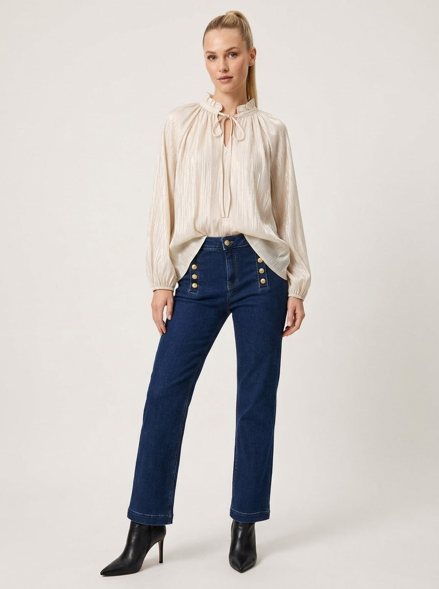 Model wearing Lilian tie-neck lurex blouse in cream, full front view