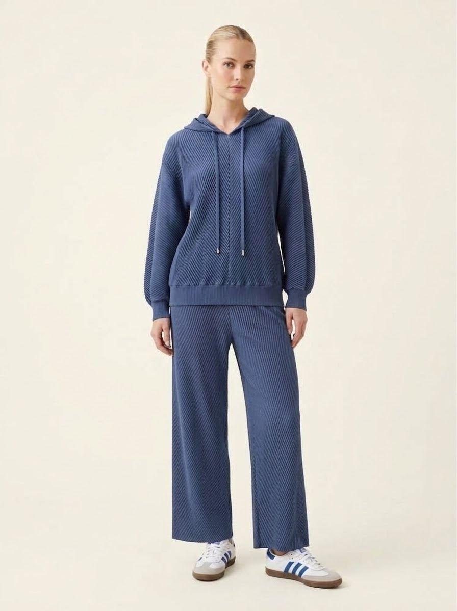 Model wearing navy Sunday hooded top with matching trousers, front view
