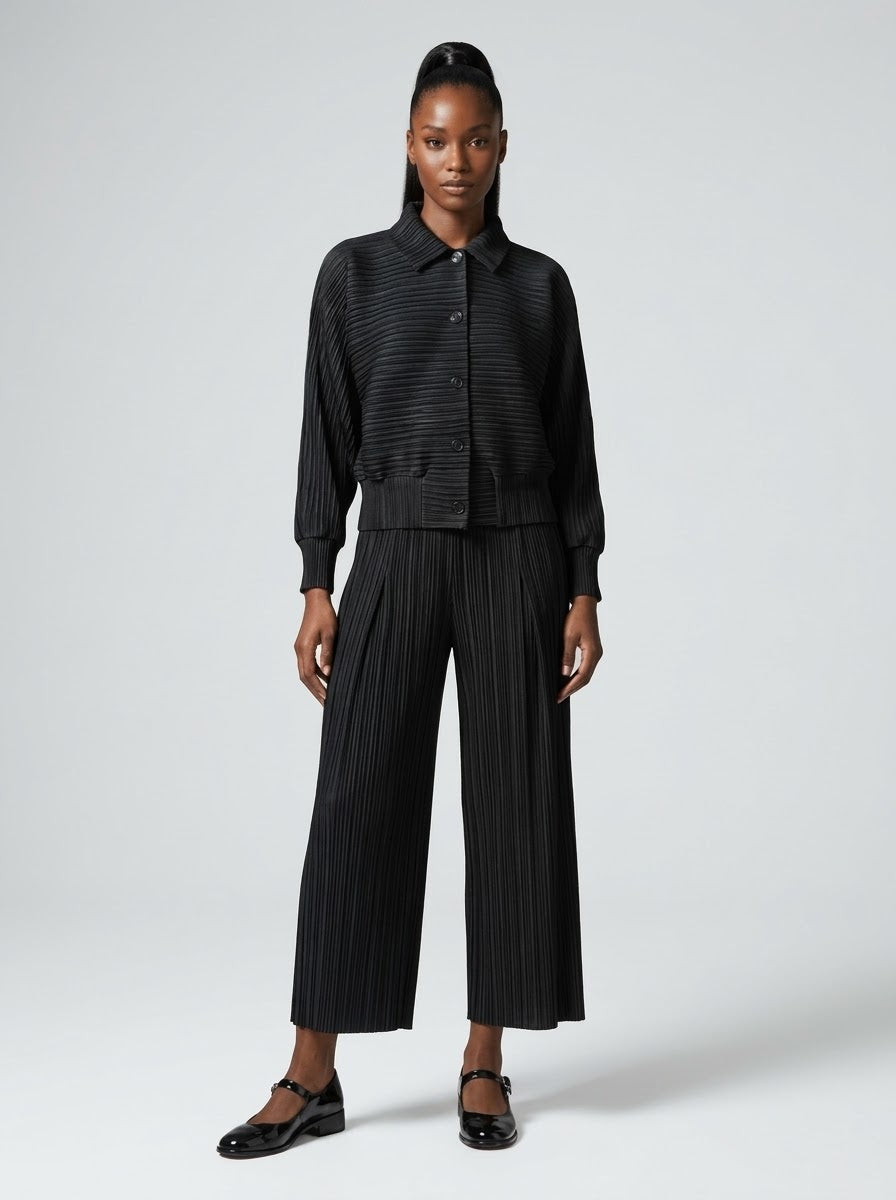 Model wearing Joanne plain pleated jacket in black with matching trousers