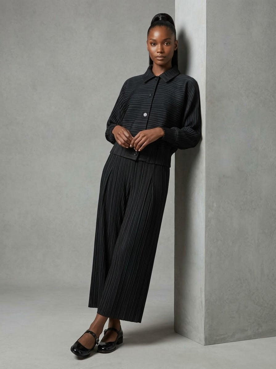 Model wearing black Joanne pleated jacket, three-quarter view