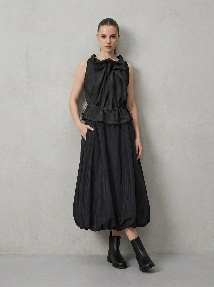 Model wearing black Marguitte balloon hem midi skirt, three-quarter view