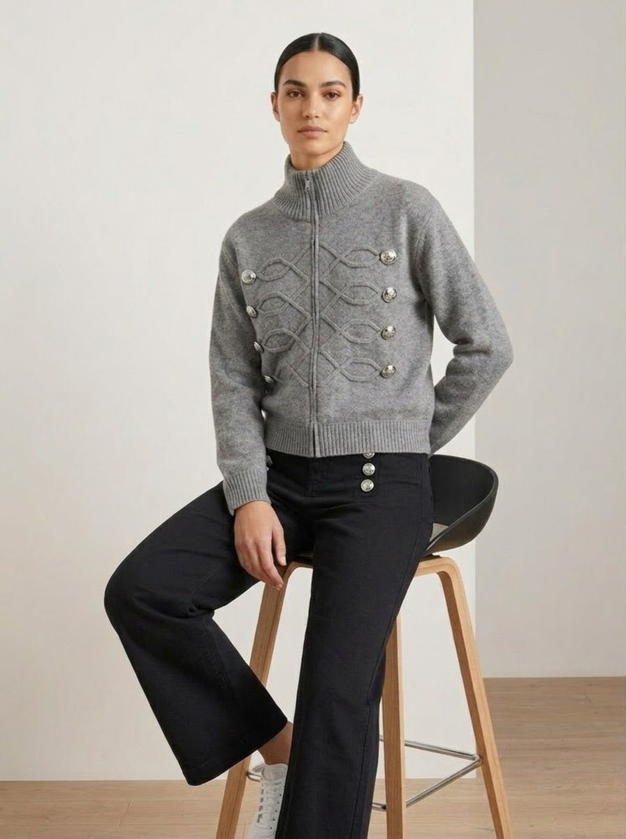 Model wearing Simone regiment knitted jacket in grey, seated front view