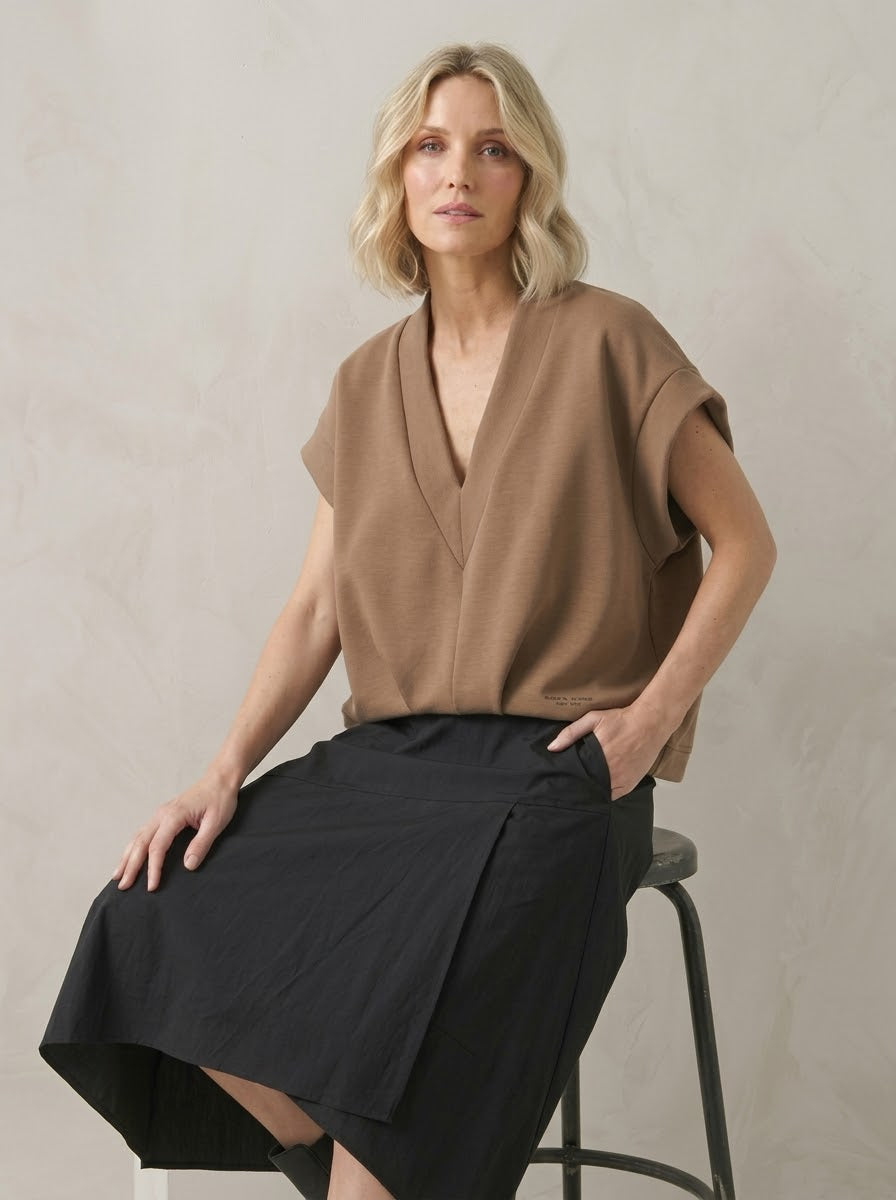 Model wearing camel Bronte scuba top, seated three-quarter view
