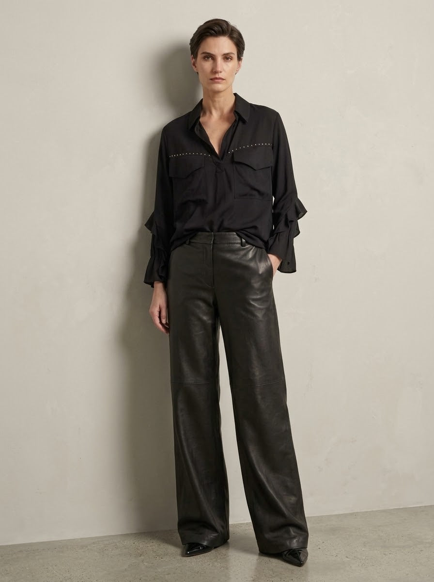 Model wearing the Fredi black wide leg pleather jeans, front view