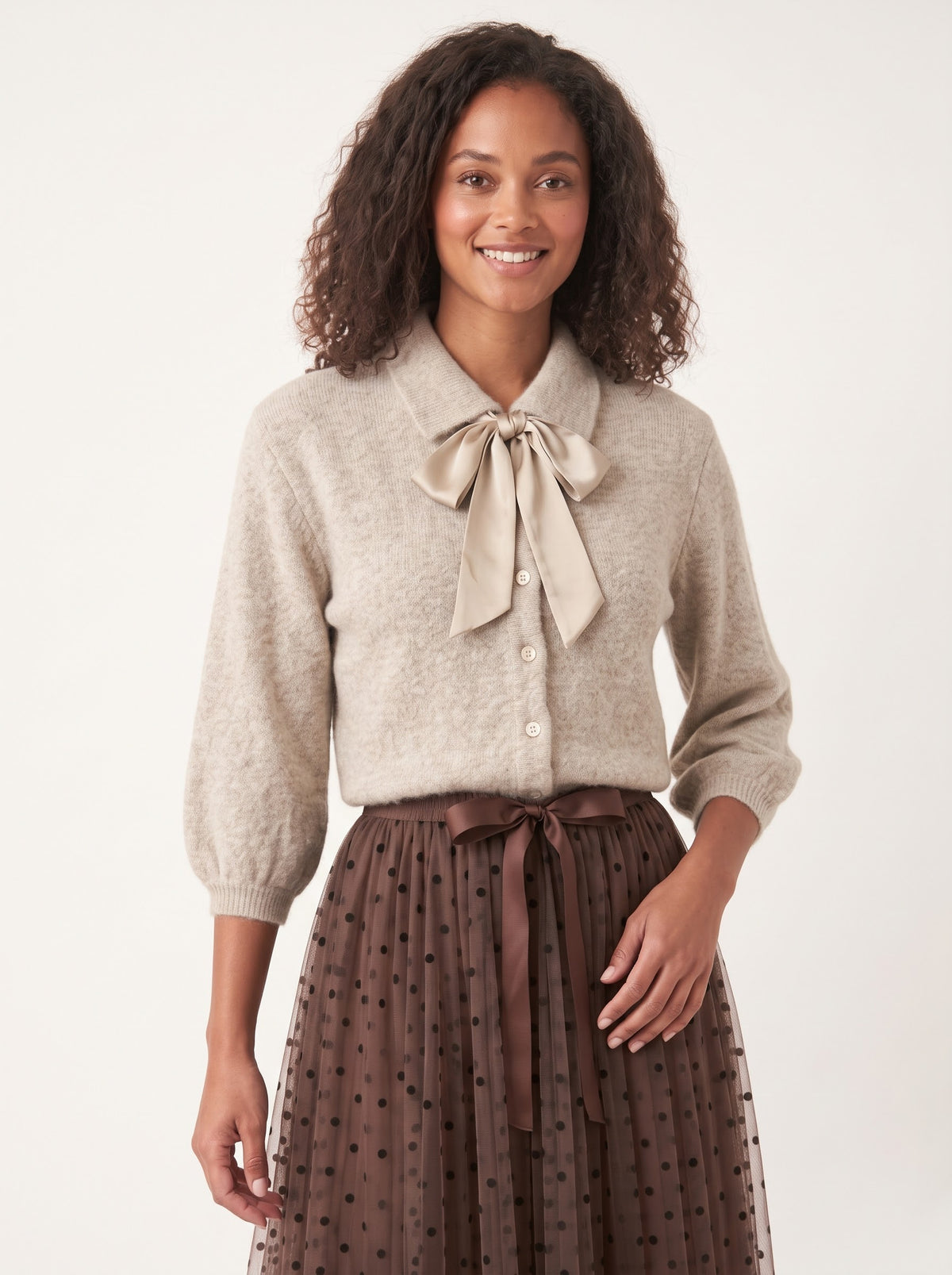 Model wearing the Antoinette oatmeal cardigan with detachable satin bow