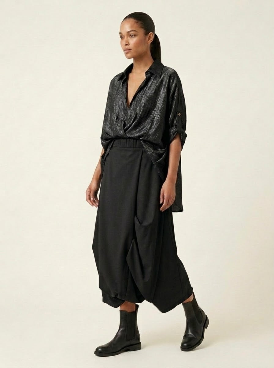 Model wearing black Roberta draped harem trousers, walking view