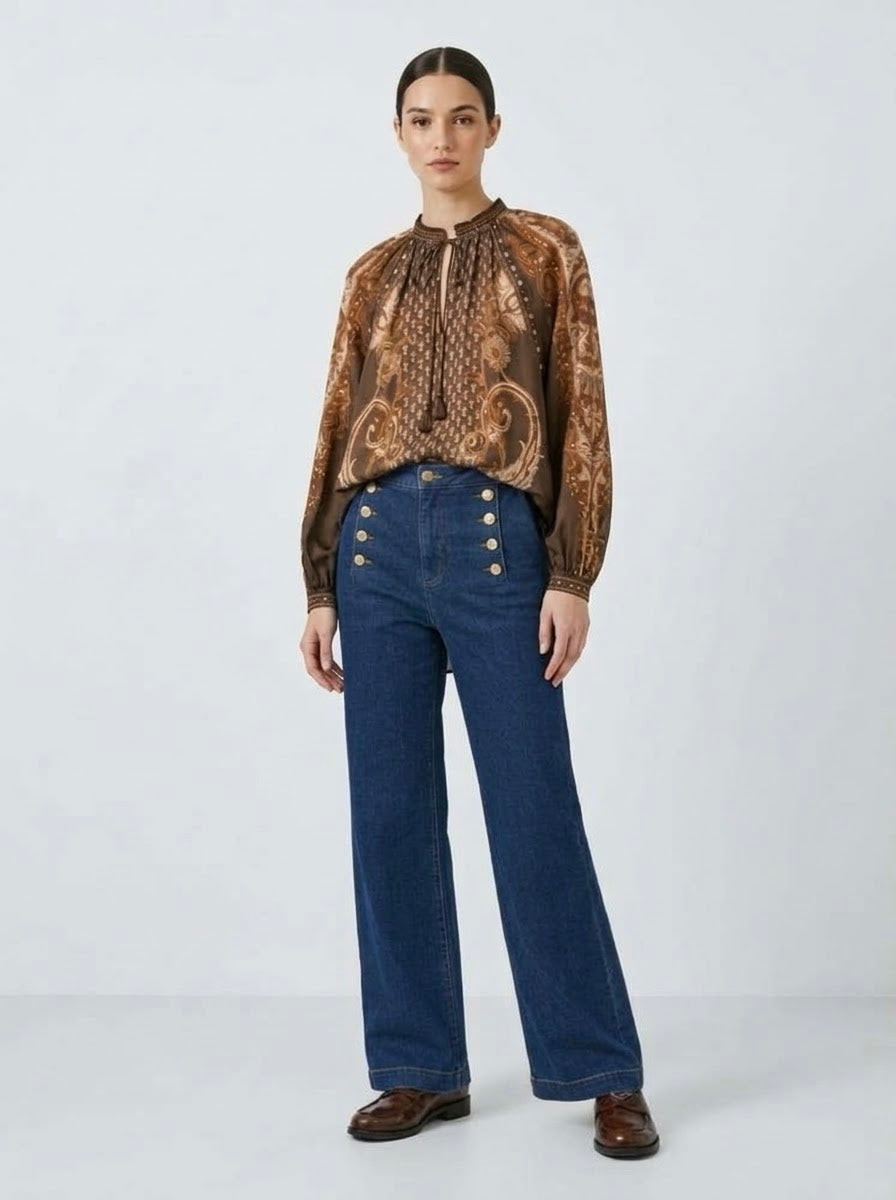 Model wearing Jessica leaf printed blouse in tan with jeans, front view