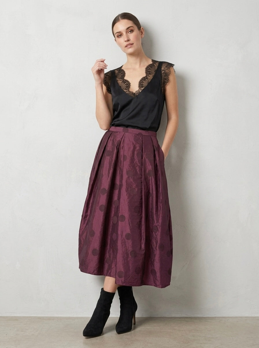 Model wearing the Brooke plum spot taffeta skirt with hands in its pocket