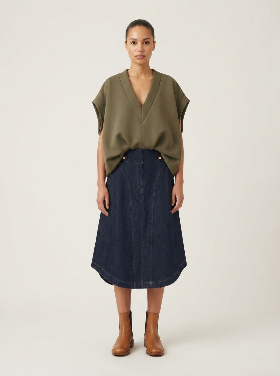 Model wearing Harper denim flared skirt with a khaki top, front view