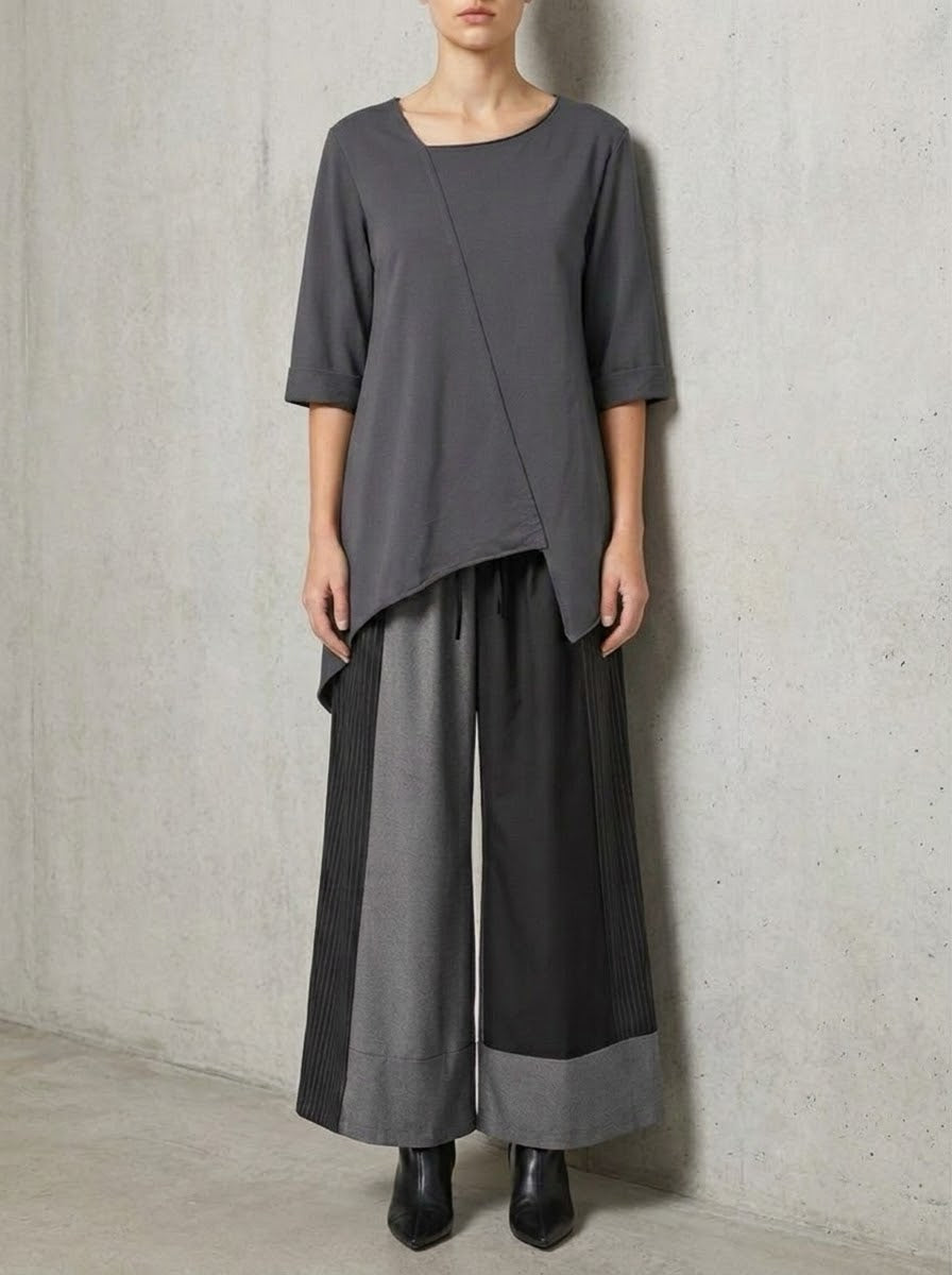 Model wearing the Maxine grey asymmetric sweatshirt top with wide-leg trousers
