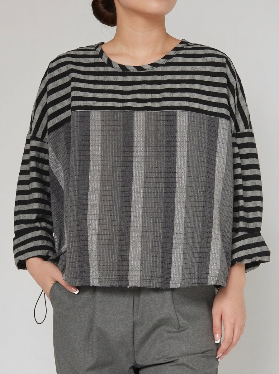 Close-up of the Elisa grey varied-stripe T-shirt showing mixed fabric textures and drawstring hem