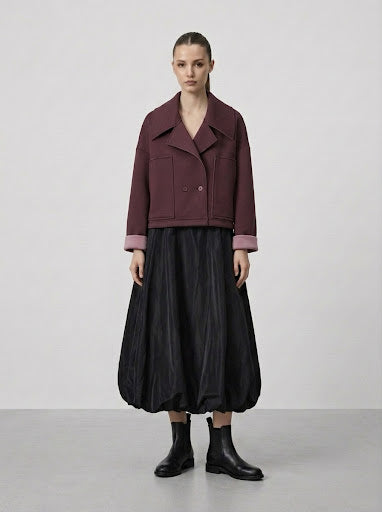 Model wearing burgundy Bronte scuba bomber jacket with black skirt, front view