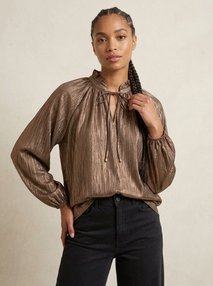 Model wearing Lilian tie-neck lurex blouse in bronze, close front view