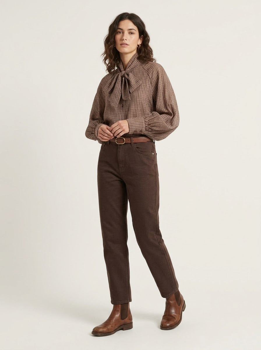 Model wearing brown Judy checked bow blouse tucked into trousers