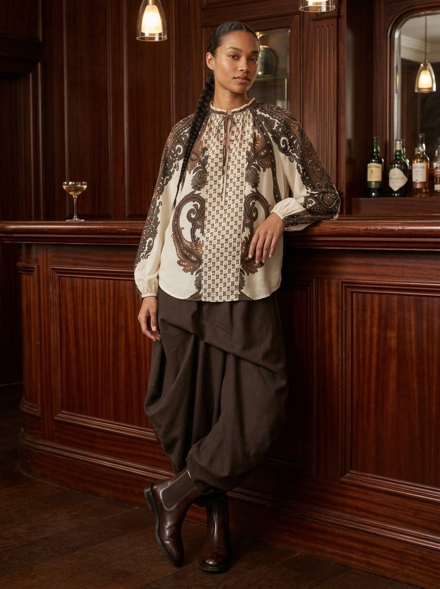 Model wearing cream Jessica leaf printed blouse in a bar setting