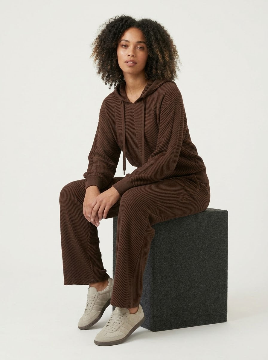 Model wearing chocolate Sunday hooded top, seated view