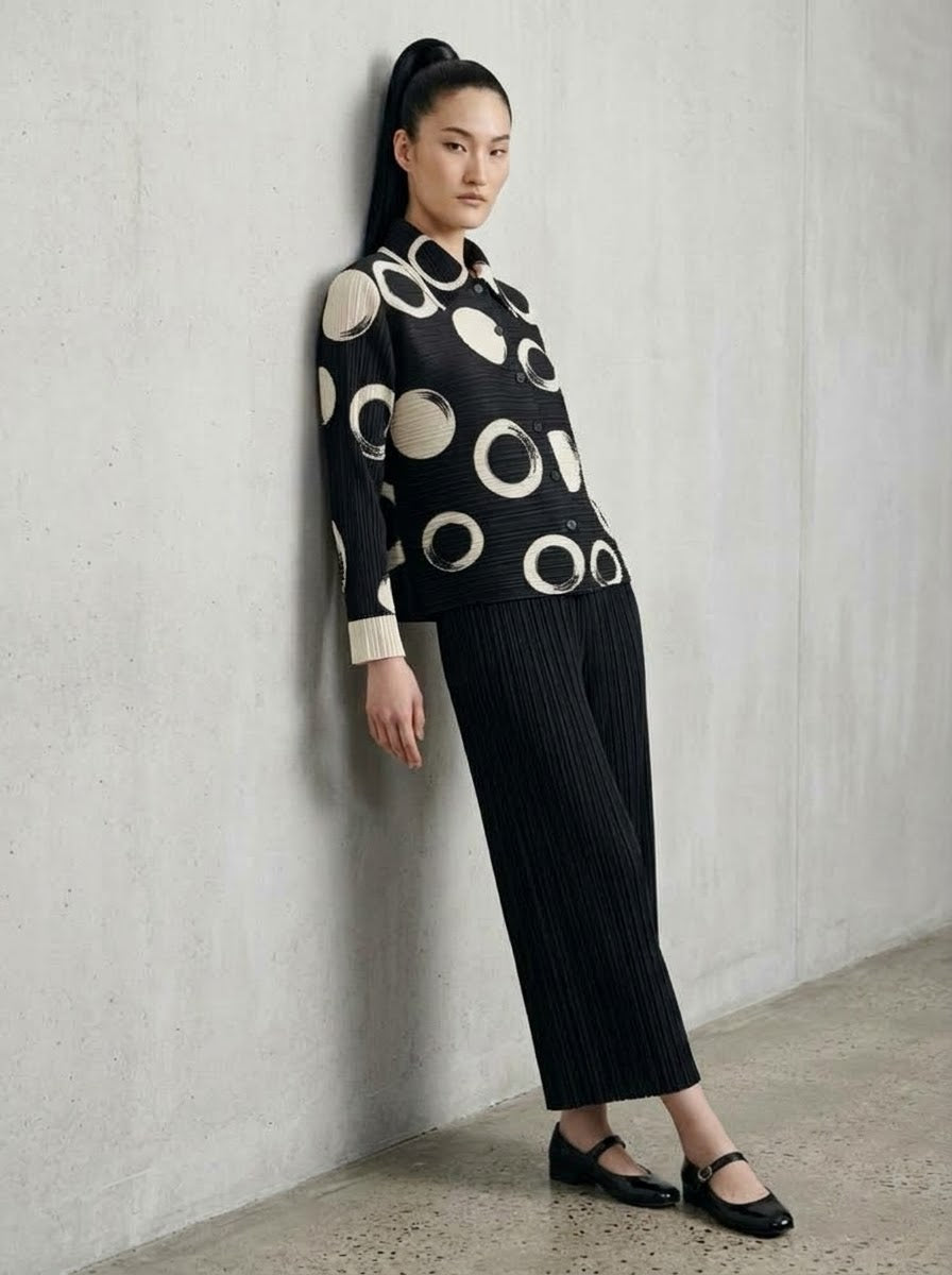 Model wearing Monroe circle print jacket with black Mikaela pleated trousers, three-quarter view